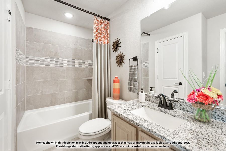 Bathroom with granite countertop vanity, tiled shower-tub combo, and decorative curtain