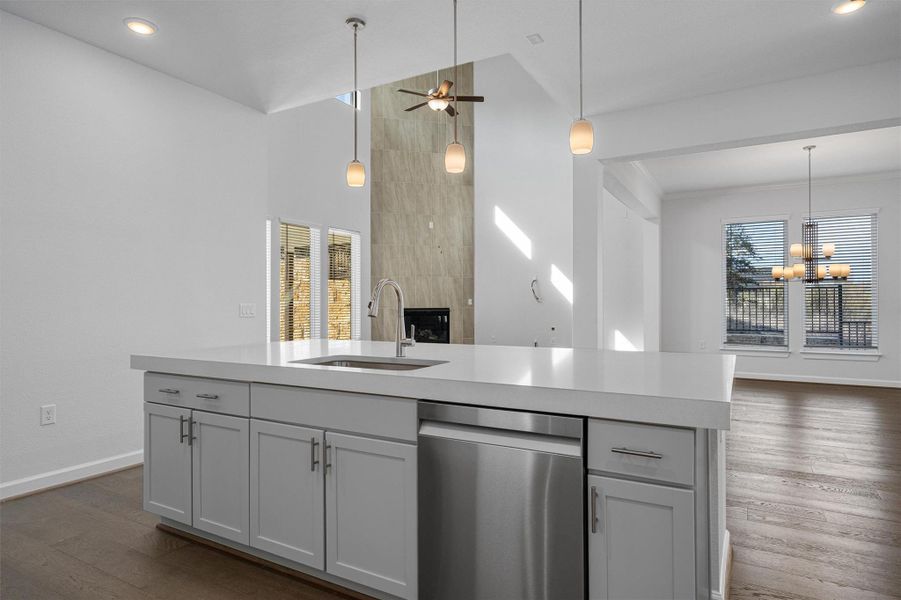 Kitchen with stainless steel dishwasher, an island with sink, dark wood finished floors, open floor plan, and ceiling fan Kitchen with stainless steel dishwasher, an island with sink, dark wood finished floors, open floor plan, and ceiling fan