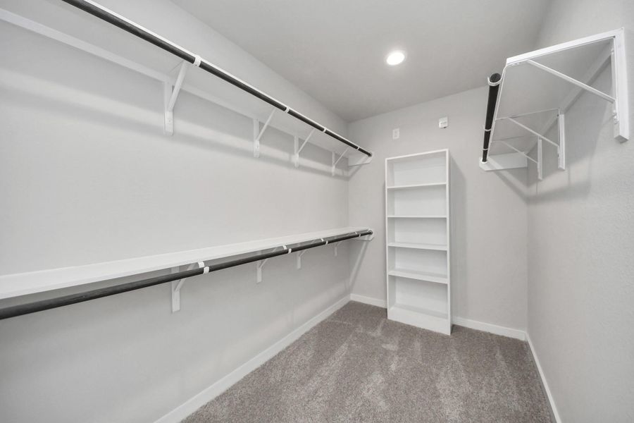 Walk-in closet that epitomizes luxury and practicality. This generously sized space features built-in shelving, offering abundant room for impeccable organization. High ceilings and recessed lighting create a bright and welcoming ambiance. Sample photo of completed home with similar floor plan. Actual colors and selections may vary. Walk-in closet that epitomizes luxury and practicality. This generously sized space features built-in shelving, offering abundant room for impeccable organization. High ceilings and recessed lighting create a bright and welcoming ambiance. Sample photo of completed home with similar floor plan. Actual colors and selections may vary.