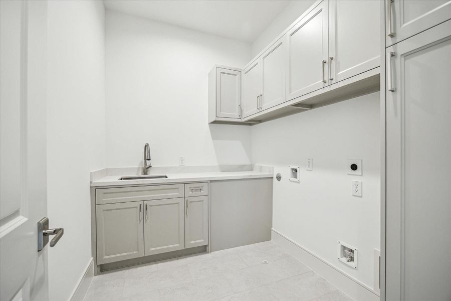 Second-floor utility room features sink and cabinet storage.