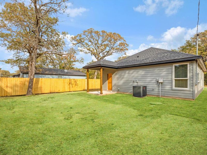 Rear view of property with a patio area and roof with shingles