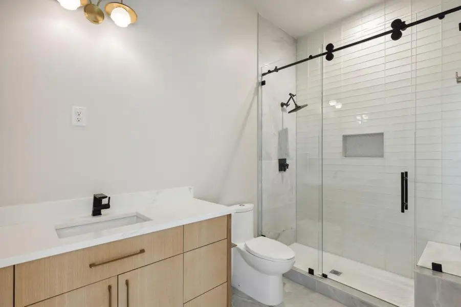 Bathroom with a stall shower, toilet, and vanity