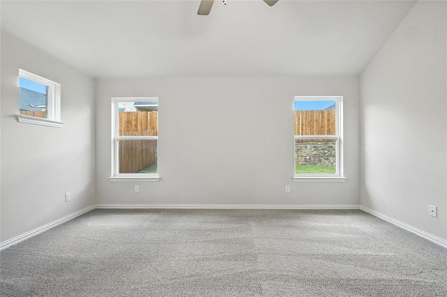 Unfurnished room with ceiling fan, healthy amount of natural light, and carpet floors Unfurnished room with ceiling fan, healthy amount of natural light, and carpet floors