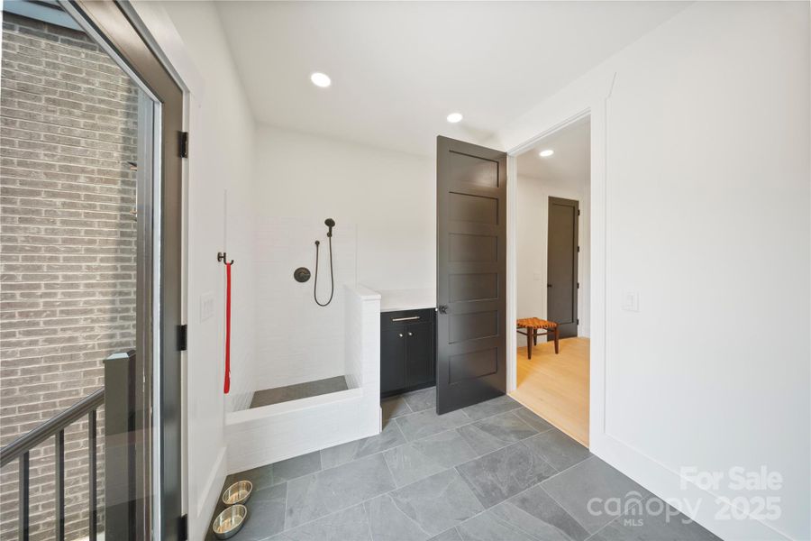 Dog wash station with stone tile floor & subway tile walls with 3-setting shower head Dog wash station with stone tile floor & subway tile walls with 3-setting shower head