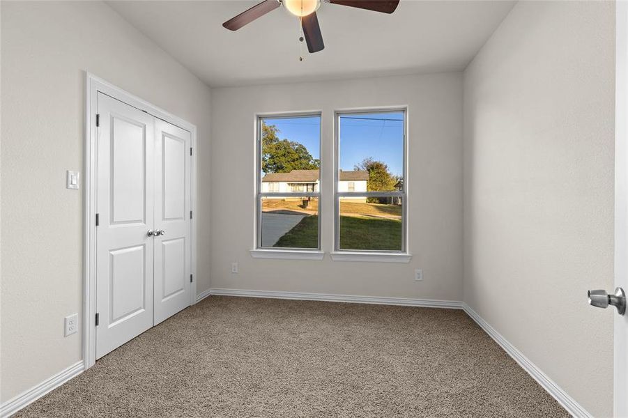 Unfurnished bedroom featuring light colored carpet, ceiling fan, and a closet
