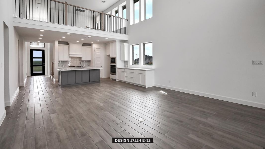 Unfurnished living room featuring dark wood-type flooring and a towering ceiling