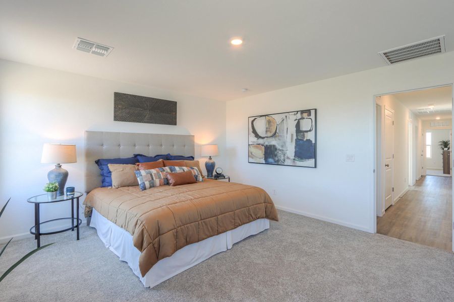 A bedroom with a bed and lamps.