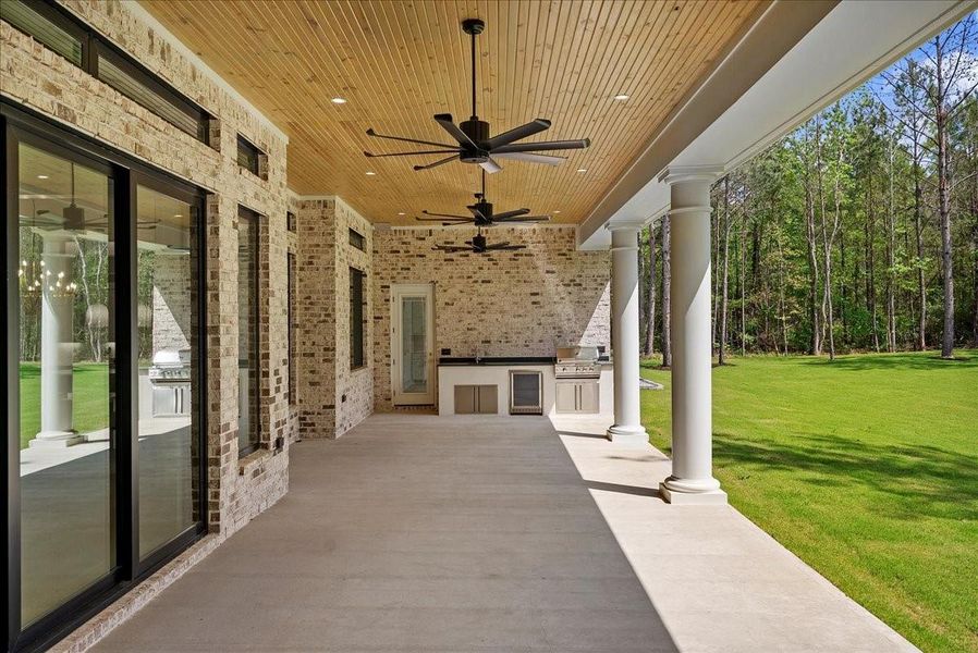 The outdoor kitchen, built-in RCS grill, refrigerator, and pass-through service window create an entertainer’s retreat designed for effortless gatherings.