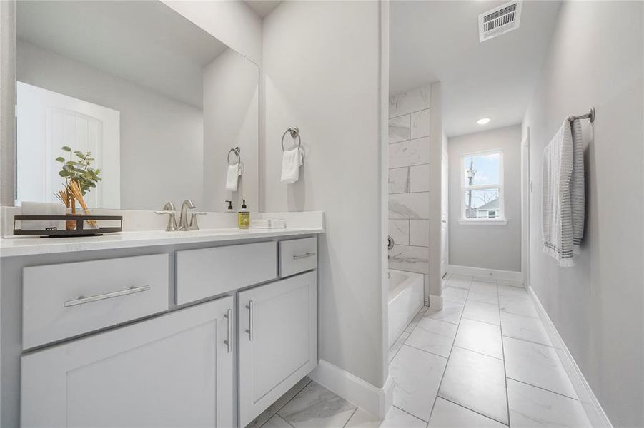 A Jack-and-Jill bathroom connects stylish secondary bedrooms, blending convenience with understated elegance. (Sample photos of a completed Bordeaux floor plan. The image may feature alternative selections and/or upgrades.)