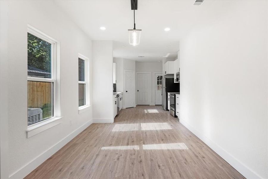 Corridor with a wealth of natural light and light wood-type flooring