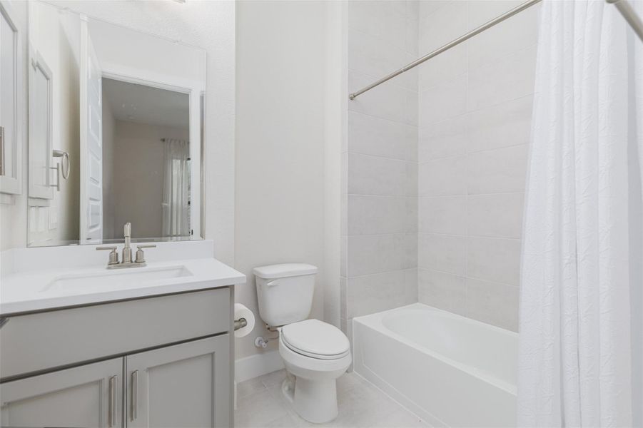 Ensuite bath with shower tub combination attached to the third auxiliary bedroom.