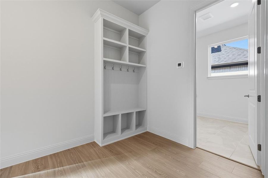 Mudroom featuring light wood finished floors and baseboards
