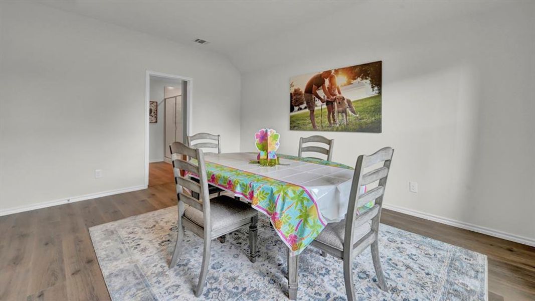 Dining room with wood finished floors and vaulted ceiling