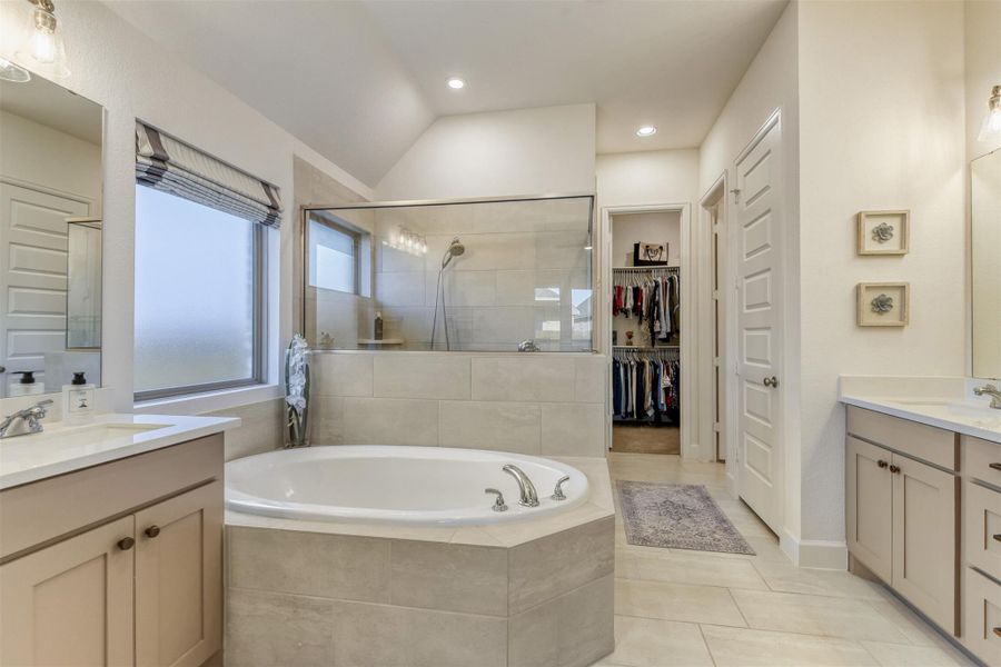 Full bathroom with vanity, a bath, light tile patterned flooring, tiled shower, and a spacious closet