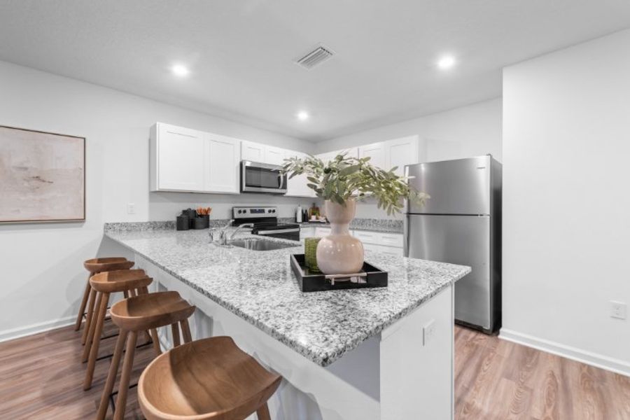 A kitchen with a table and stools. A kitchen with a table and stools.