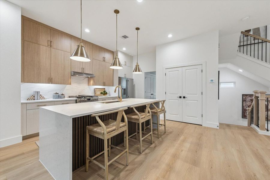 Modern kitchen featuring quartz countertops and bar seating Modern kitchen featuring quartz countertops and bar seating