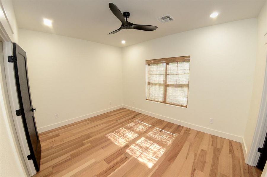 Empty room with a ceiling fan, light wood-type flooring, and recessed lighting
