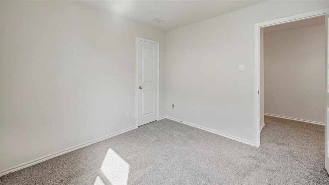 Spare room with light colored carpet and baseboards