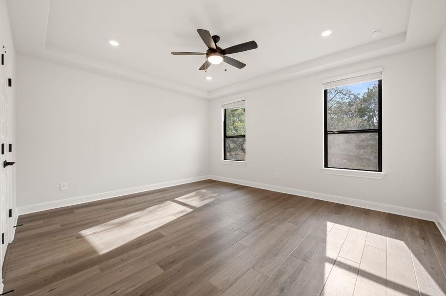 Primary bedroom with tray ceilings and ensuite bath