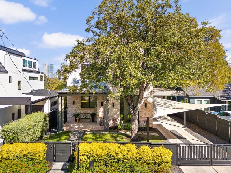 Rear view of property featuring a patio area, a fenced front yard, a gate, and brick siding Rear view of property featuring a patio area, a fenced front yard, a gate, and brick siding