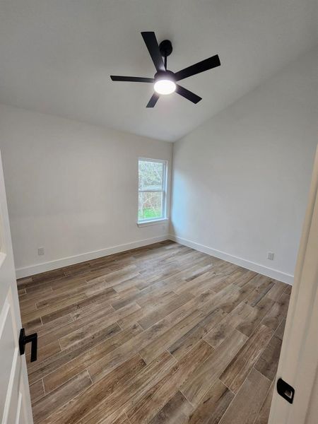 Empty room featuring wood tiled floors and ceiling fan
