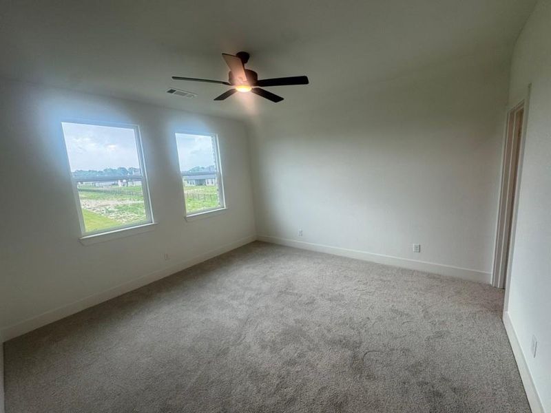 Spacious room featuring two windows, recessed ceiling fan with lighting, light gray carpet, white walls, and a white baseboard trim