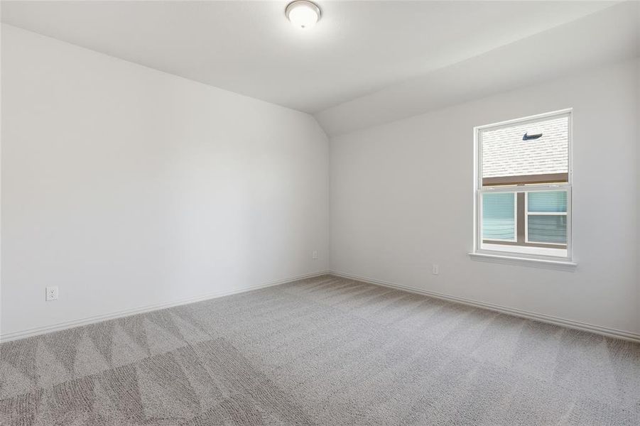 Spacious interior room featuring light gray patterned carpet, white baseboards, and bright white walls