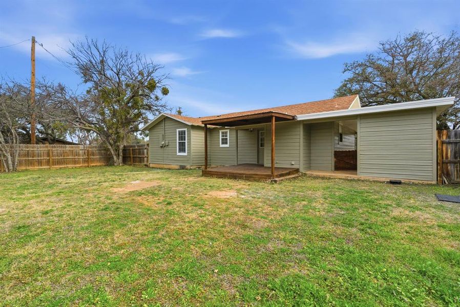 Rear view of house featuring a fenced backyard, a deck, and a shingled roof Rear view of house featuring a fenced backyard, a deck, and a shingled roof