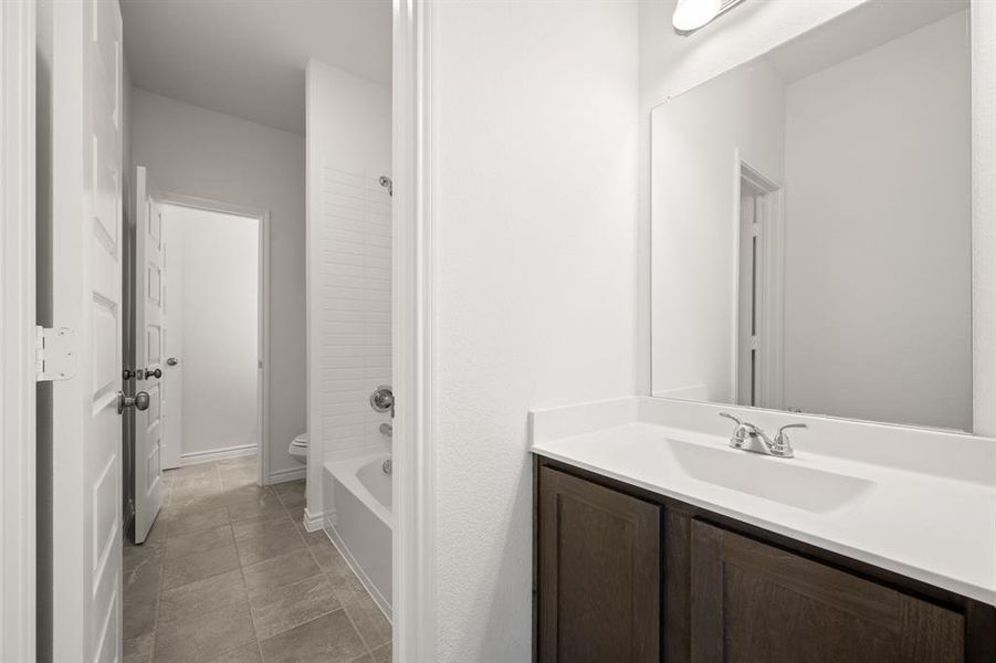 Bathroom with vanity, toilet, and tile patterned floors