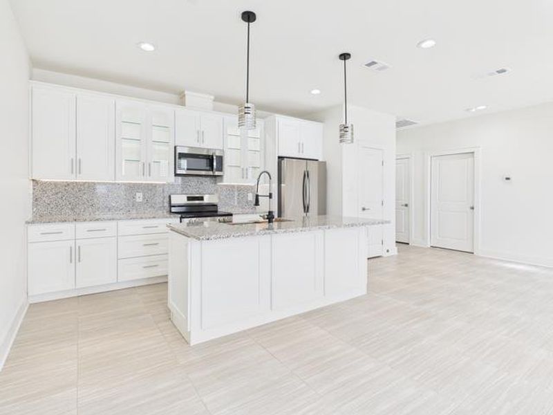 Kitchen featuring pendant lighting, white cabinetry, decorative backsplash, stainless steel appliances, and recessed lighting Kitchen featuring pendant lighting, white cabinetry, decorative backsplash, stainless steel appliances, and recessed lighting