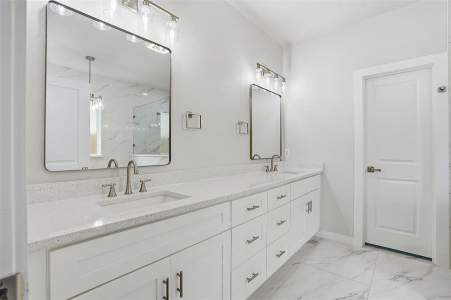 Dual vanity with white cabinetry, light-toned countertops, undermount sinks, and brushed nickel fixtures