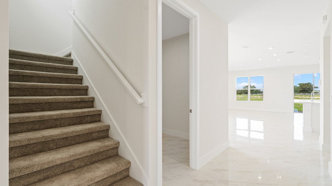 The Sweetgum stairs and view of living area of two story home in Trailside in Mount Dora by DRB Homes