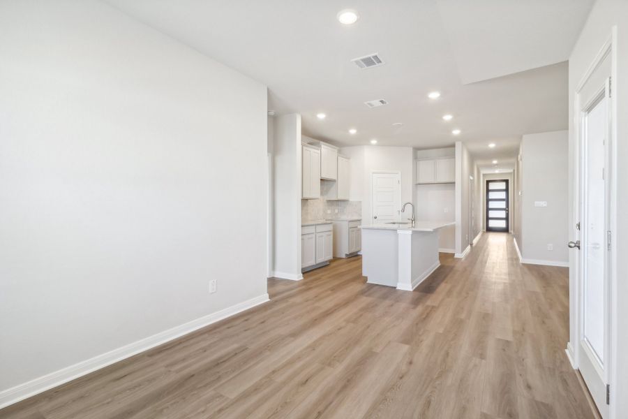 Dining room and kitchen in the Briscoe floorplan at a Meritage Homes community.