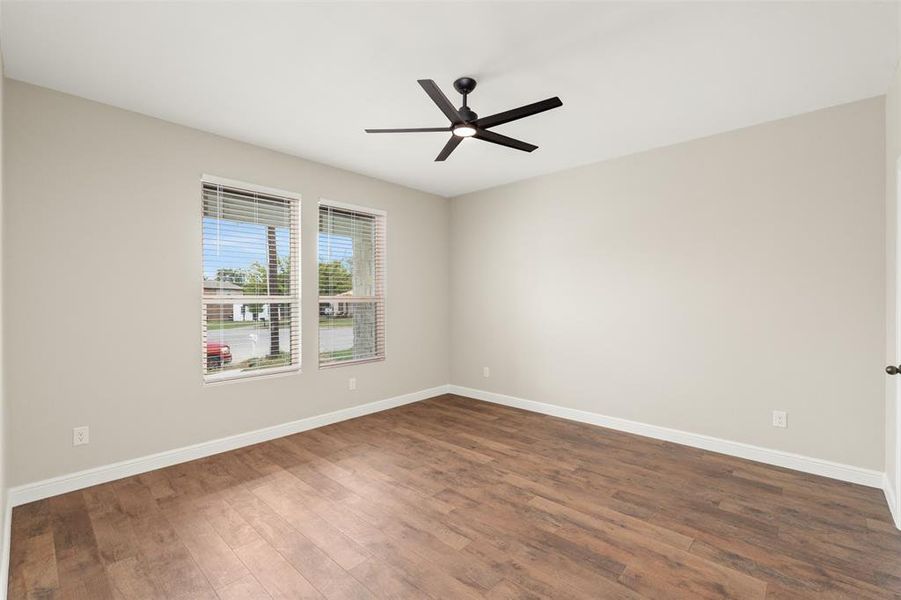 Unfurnished room with dark wood-type flooring and a ceiling fan