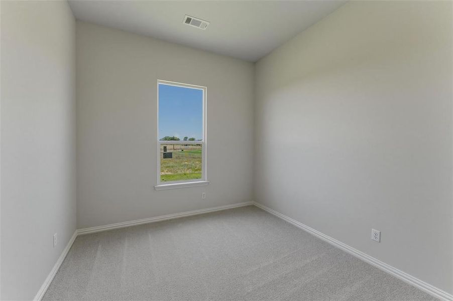 Bright room featuring a single window, light gray carpeting, and white trim
