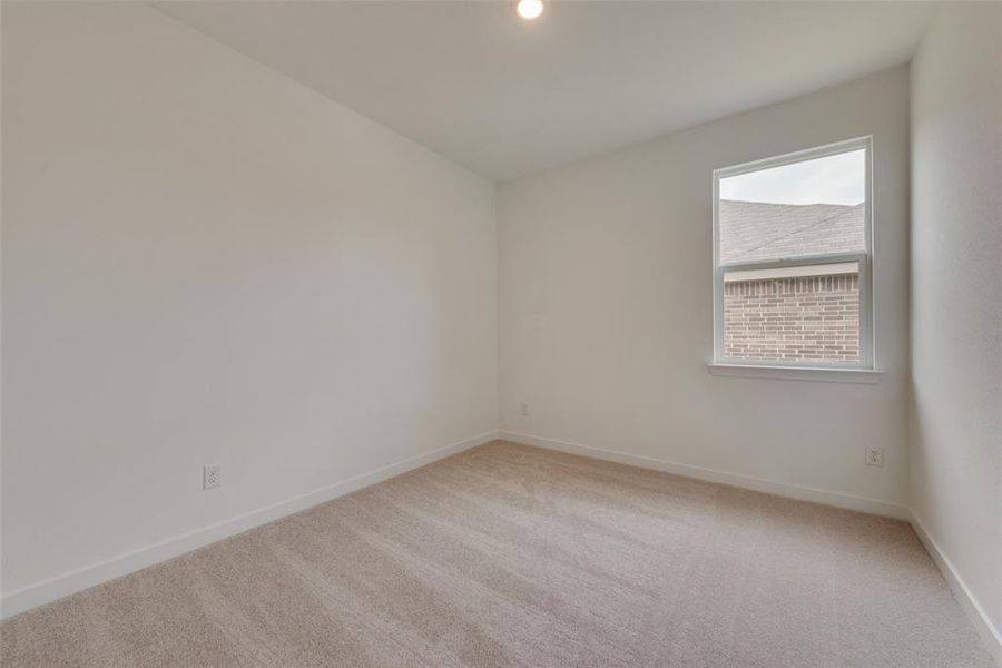 Empty room featuring light colored carpet