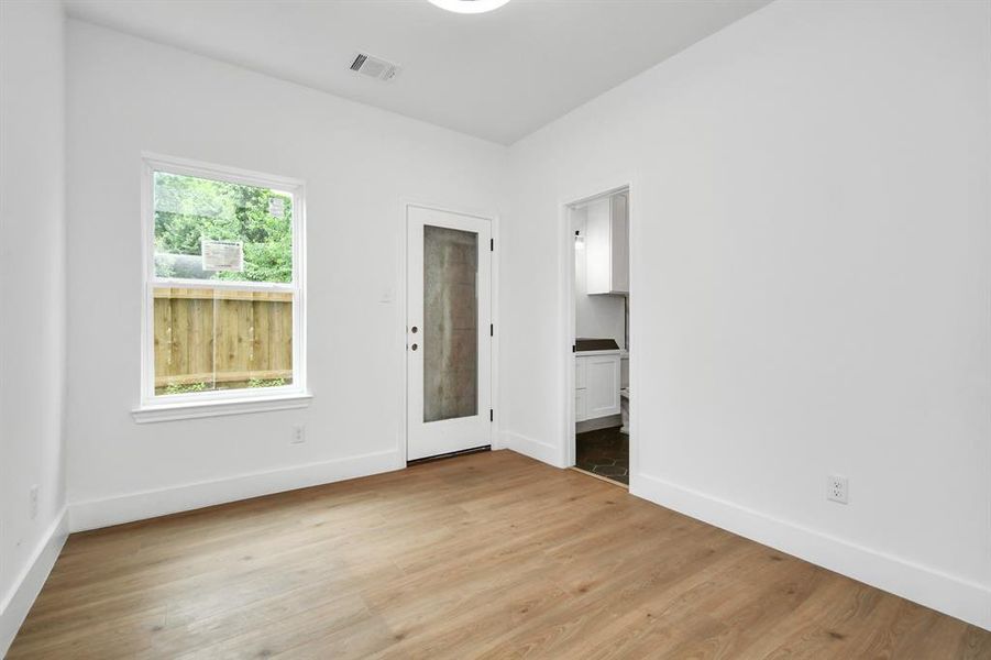 First floor bedroom features a window, en-suite bathroom and access to the backyard.