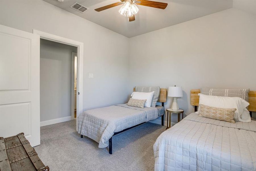 Carpeted bedroom with ceiling fan and baseboards