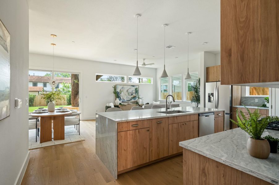 Blonde wood flooring and kitchen island flow into an airy, naturally illuminated open-concept living space. Blonde wood flooring and kitchen island flow into an airy, naturally illuminated open-concept living space.