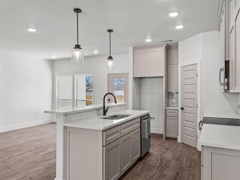 Kitchen with visible vents, a sink, wood finished floors, appliances with stainless steel finishes, and light countertops