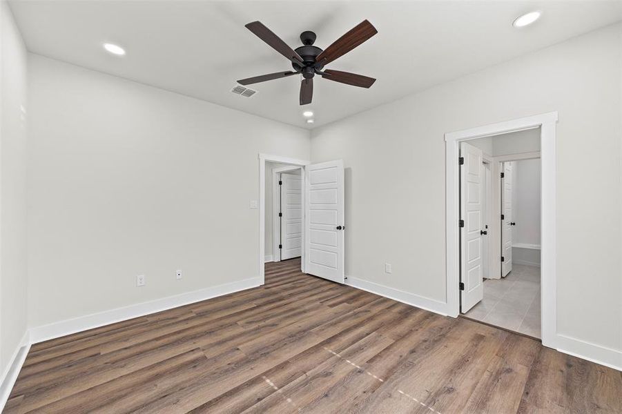Unfurnished bedroom with wood finished floors, ceiling fan, and recessed lighting Unfurnished bedroom with wood finished floors, ceiling fan, and recessed lighting