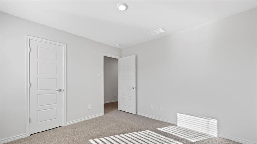 Unfurnished bedroom featuring light colored carpet and baseboards Unfurnished bedroom featuring light colored carpet and baseboards