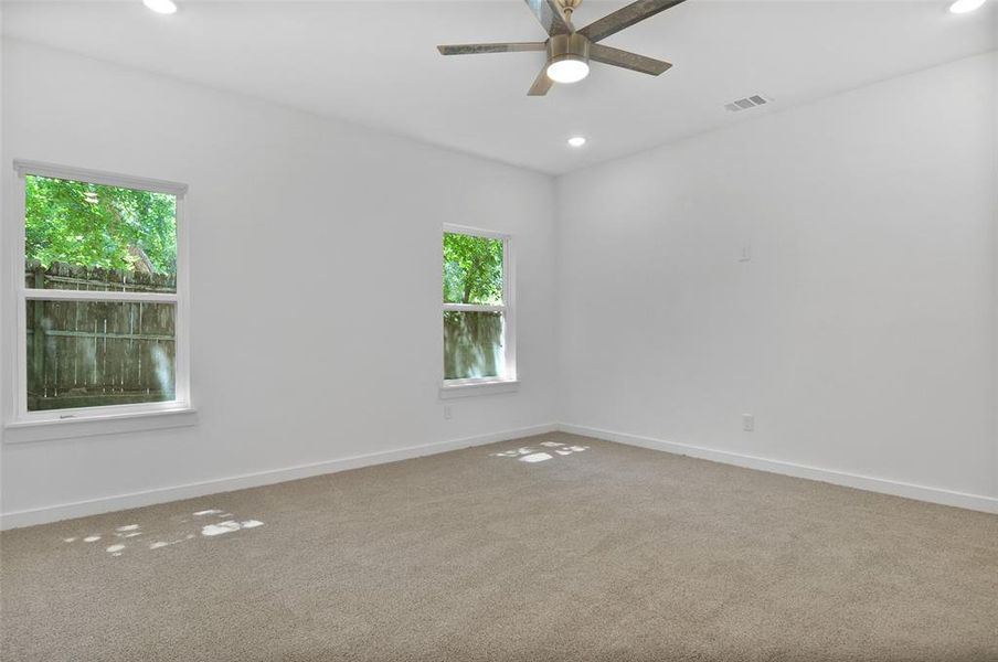 Carpeted spare room with ceiling fan