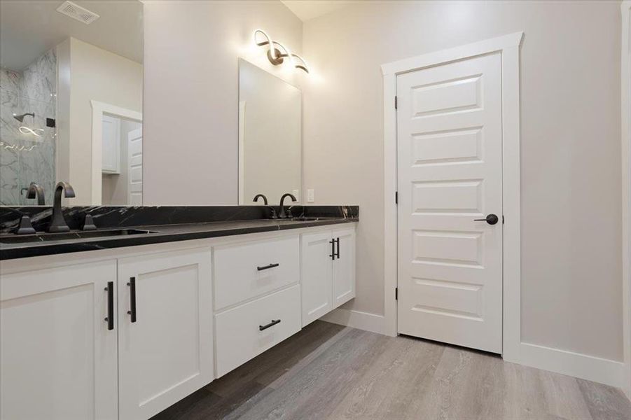 Bathroom featuring vanity, walk in shower, and hardwood / wood-style flooring