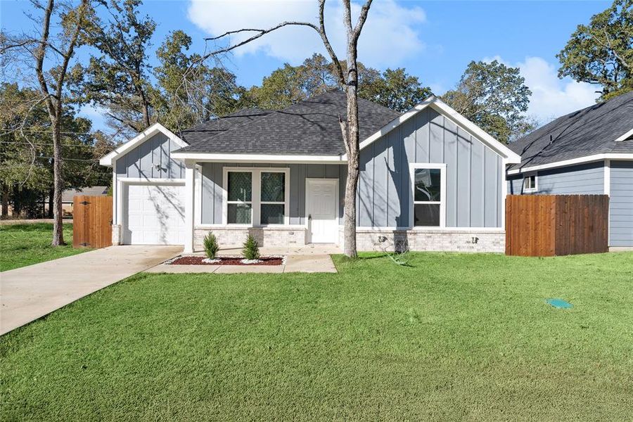 View of front of home with a front yard and a garage