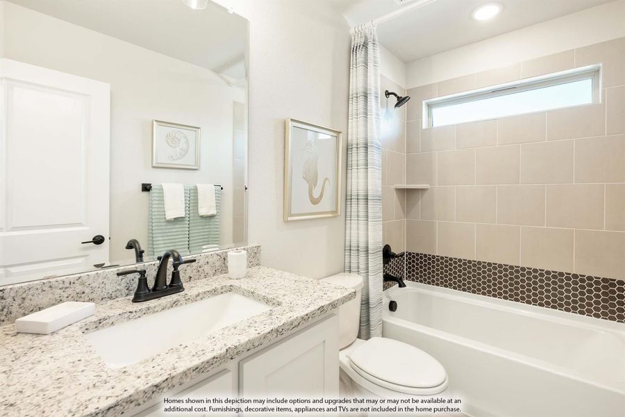 Bathroom with granite countertop vanity, tub-shower combo with beige tile surround and dark hexagon accent tile