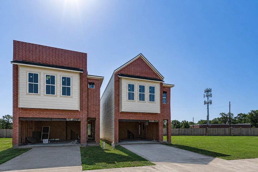 Contemporary new-construction exterior showcasing the home’s modern brick-and-siding elevation, clean architectural lines, upper-level windows, and attached garage. The open garage and visible framing reflect the active construction stage, while the wide driveway, green lawn, and bright blue sky help highlight the fresh, low-maintenance setting within the developing boutique community. Contemporary new-construction exterior showcasing the home’s modern brick-and-siding elevation, clean architectural lines, upper-level windows, and attached garage. The open garage and visible framing reflect the active construction stage, while the wide driveway, green lawn, and bright blue sky help highlight the fresh, low-maintenance setting within the developing boutique community.