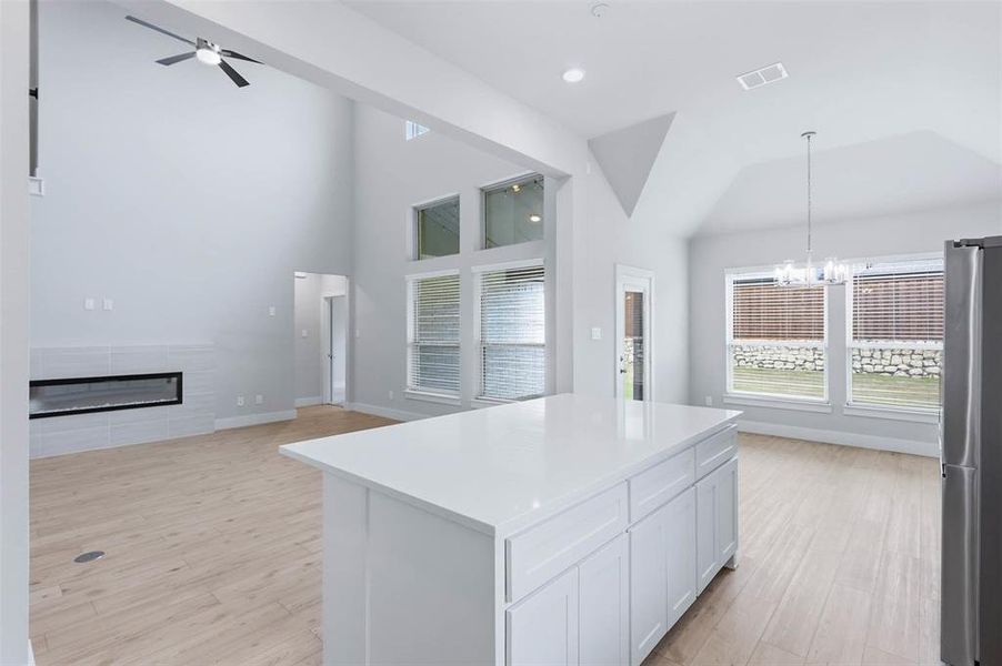 Kitchen view with spacious island, abundant cabinetry, and natural light from nearby windows.