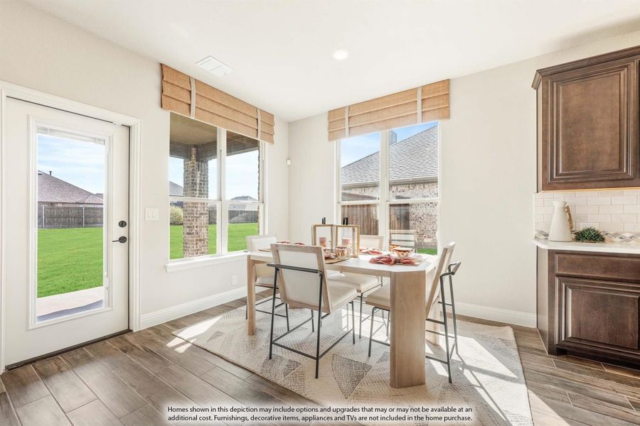 Bright breakfast nook with wood-look floors, large windows, and a light wood dining table with four chairs. Bright breakfast nook with wood-look floors, large windows, and a light wood dining table with four chairs.