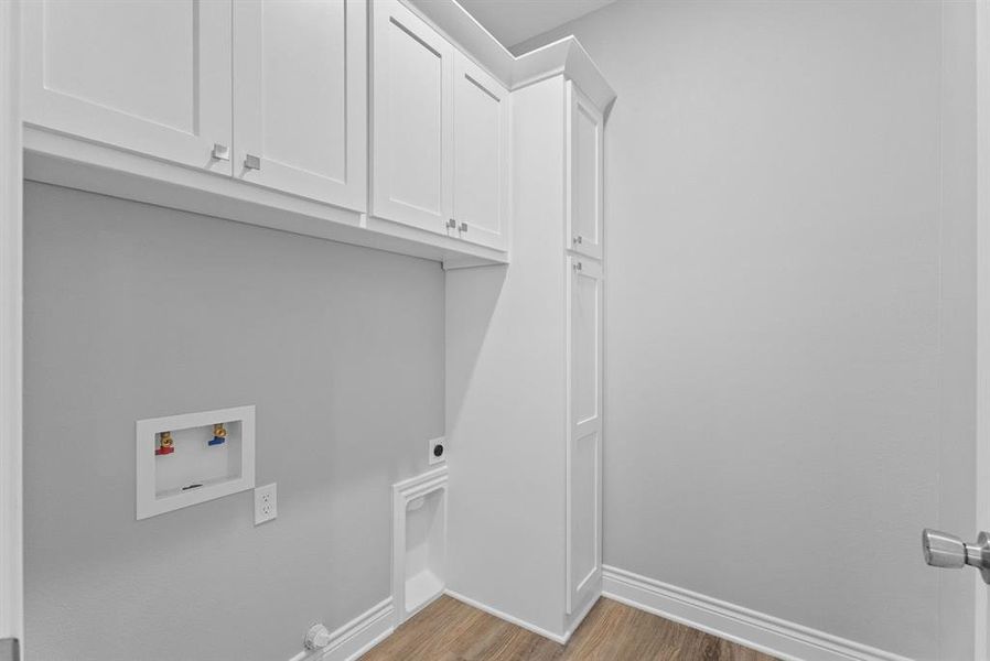 Laundry area with light wood-style flooring, cabinet space, hookup for a washing machine, and electric dryer hookup
